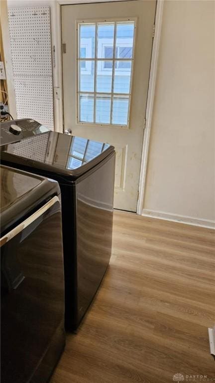 washroom with light hardwood / wood-style flooring and washer and dryer