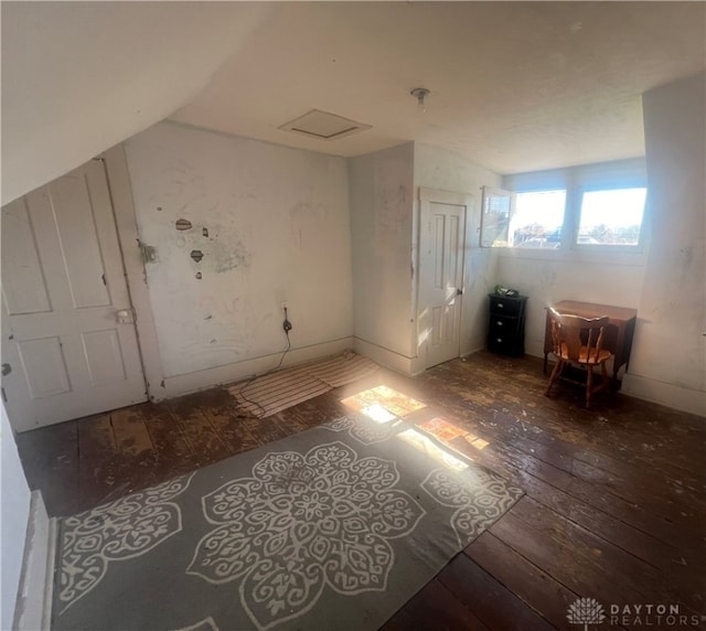 additional living space featuring dark wood-type flooring and vaulted ceiling