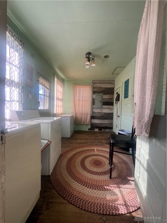 interior space featuring electric panel, wooden walls, and washing machine and clothes dryer