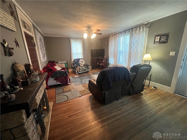 living room with ornamental molding, wood-type flooring, and ceiling fan