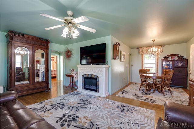 living room featuring ceiling fan with notable chandelier and hardwood / wood-style flooring