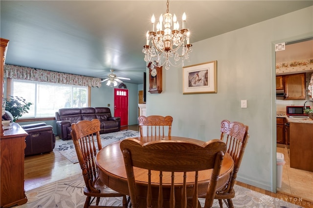 dining space featuring ceiling fan with notable chandelier and light hardwood / wood-style floors