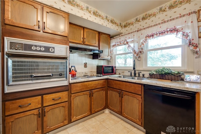 kitchen with black appliances, light tile patterned floors, sink, and tasteful backsplash