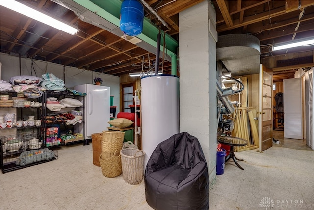 basement featuring gas water heater and white refrigerator