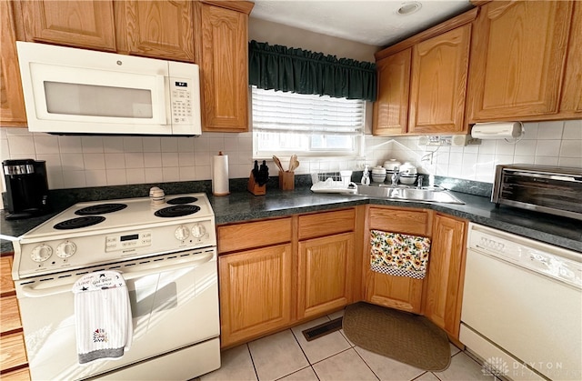 kitchen with white appliances, light tile patterned floors, backsplash, and sink