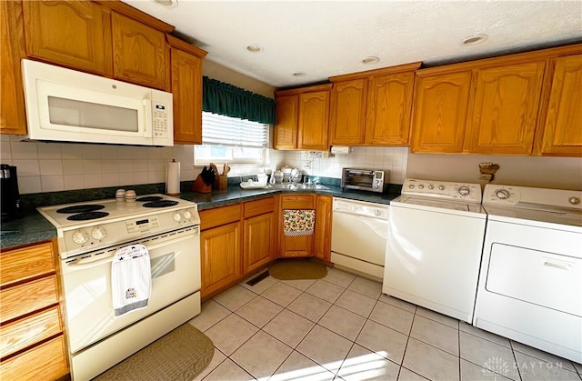 kitchen featuring separate washer and dryer, tasteful backsplash, light tile patterned floors, and white appliances