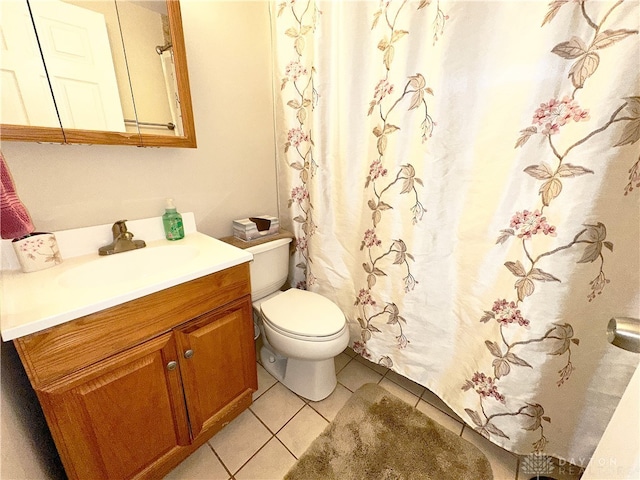 bathroom with toilet, vanity, and tile patterned floors