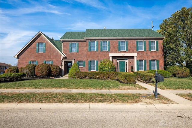 colonial inspired home with a front lawn