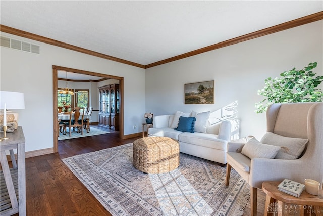 living room featuring a chandelier, crown molding, and dark hardwood / wood-style flooring