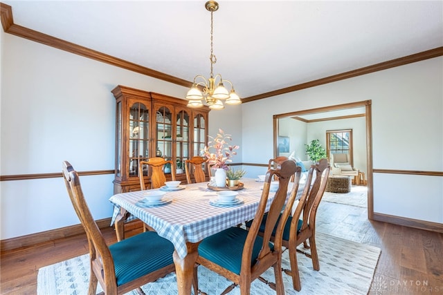 dining space featuring an inviting chandelier, hardwood / wood-style floors, and ornamental molding