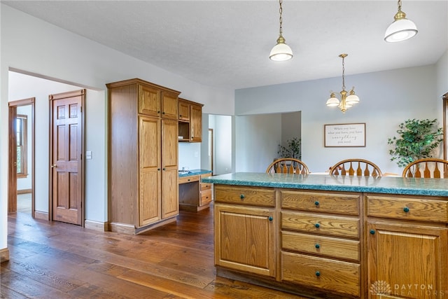 kitchen with a chandelier, decorative light fixtures, dark hardwood / wood-style floors, and a textured ceiling