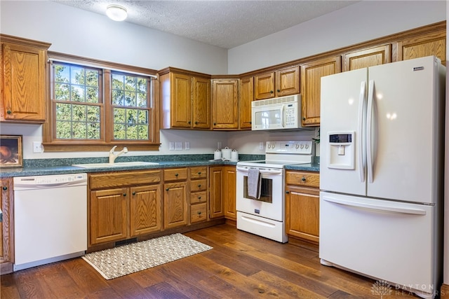 kitchen with sink, white appliances, a textured ceiling, and dark hardwood / wood-style floors