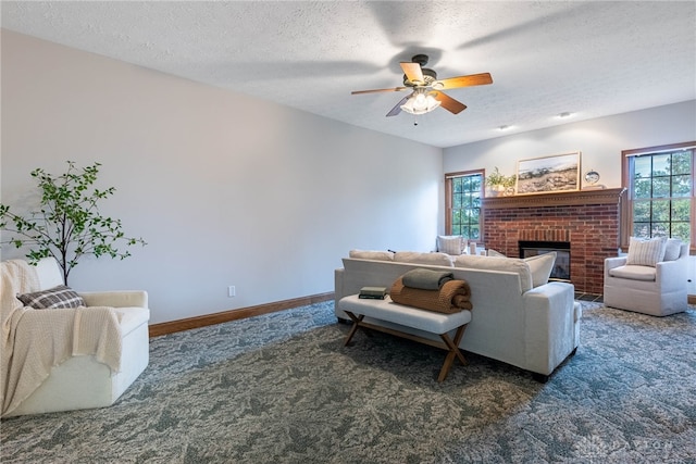 living room featuring a textured ceiling, dark carpet, a healthy amount of sunlight, and a fireplace