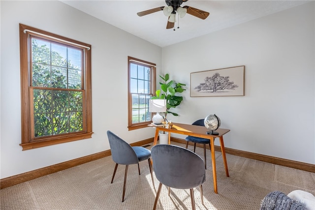 carpeted office space with ceiling fan and plenty of natural light