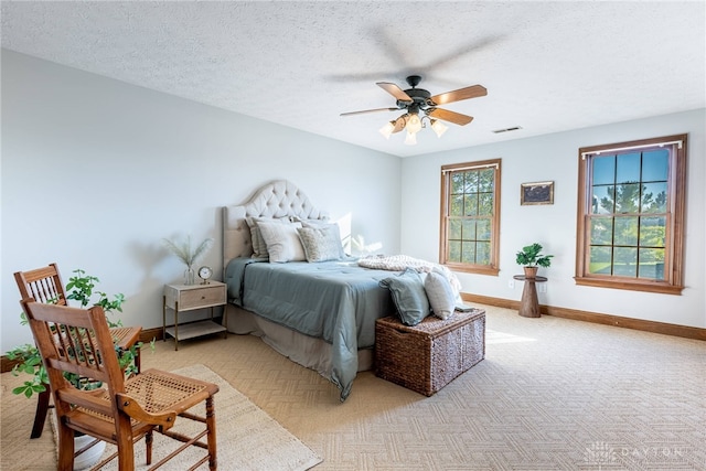 carpeted bedroom with a textured ceiling and ceiling fan