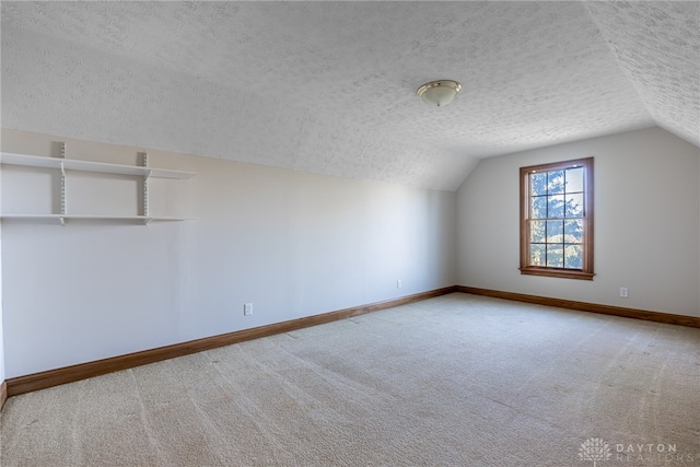 bonus room with a textured ceiling, light carpet, and lofted ceiling