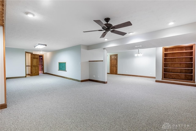 empty room featuring a textured ceiling, light carpet, and ceiling fan with notable chandelier