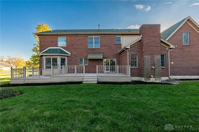 back of house featuring a wooden deck and a yard