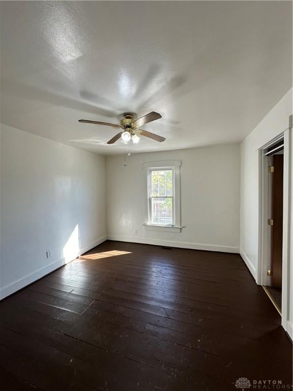 spare room with a ceiling fan, baseboards, and hardwood / wood-style flooring