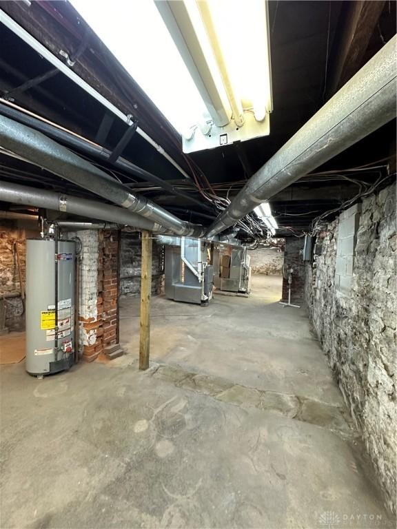 unfinished basement featuring heating unit and gas water heater