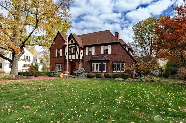 english style home featuring a front yard