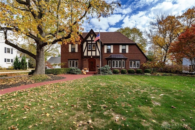 tudor-style house with a front lawn