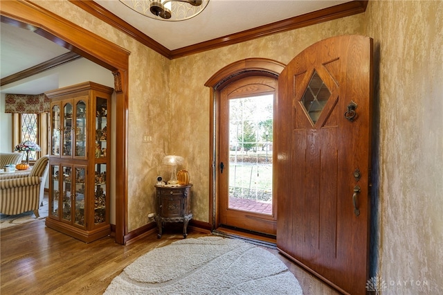 entrance foyer with ornamental molding and hardwood / wood-style floors