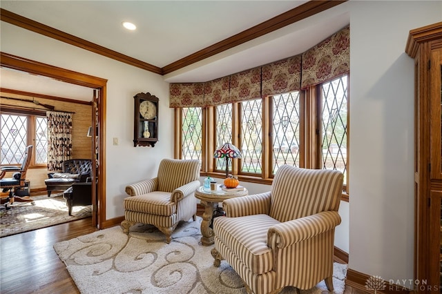 sitting room with hardwood / wood-style flooring, a healthy amount of sunlight, and crown molding