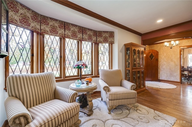 sitting room featuring light hardwood / wood-style floors, a chandelier, plenty of natural light, and crown molding