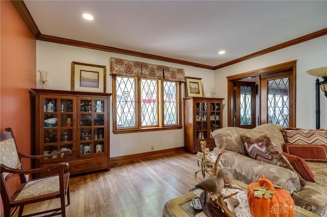 living room with ornamental molding and light hardwood / wood-style flooring