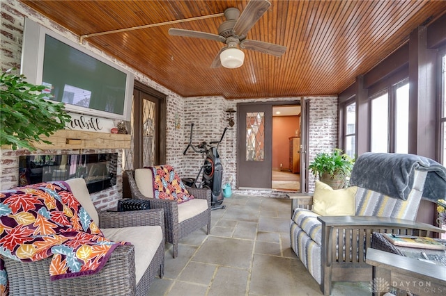 sunroom featuring wood ceiling and ceiling fan