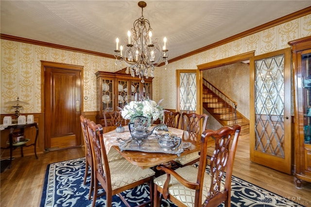 dining area with hardwood / wood-style floors, a chandelier, and crown molding