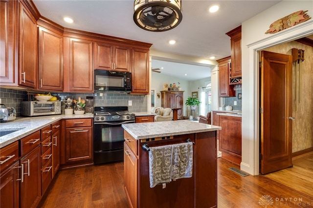 kitchen featuring black appliances, dark hardwood / wood-style floors, and backsplash