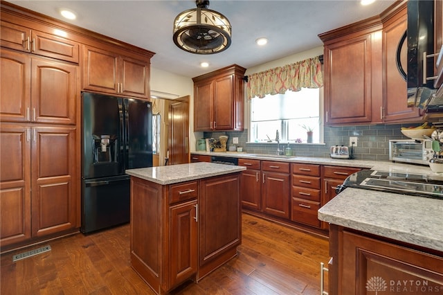 kitchen featuring black appliances, sink, dark hardwood / wood-style floors, and a center island