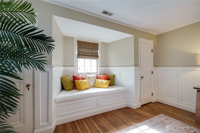 sitting room featuring light wood-type flooring and crown molding