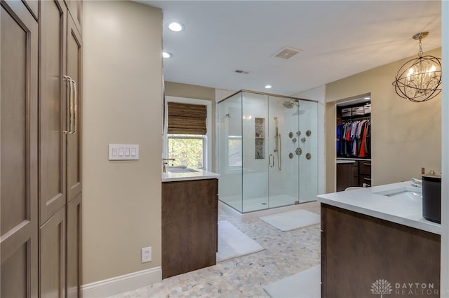 bathroom featuring vanity, a chandelier, and a shower with door