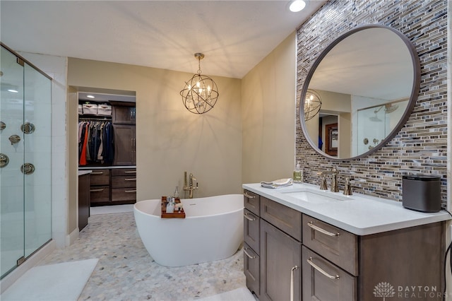 bathroom featuring decorative backsplash, a notable chandelier, vanity, and plus walk in shower