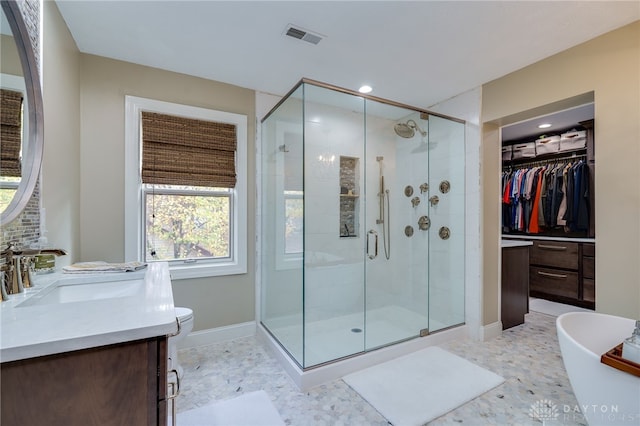 full bathroom featuring vanity, shower with separate bathtub, and toilet