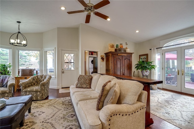 living room featuring french doors, ceiling fan with notable chandelier, hardwood / wood-style flooring, and high vaulted ceiling