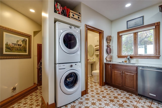 clothes washing area with stacked washer and dryer and sink