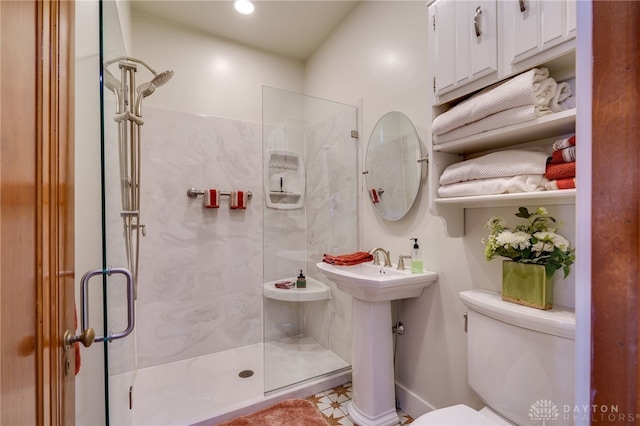 bathroom featuring a shower with door, tile patterned floors, and toilet