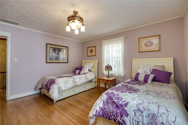 bedroom featuring hardwood / wood-style flooring, a textured ceiling, and crown molding