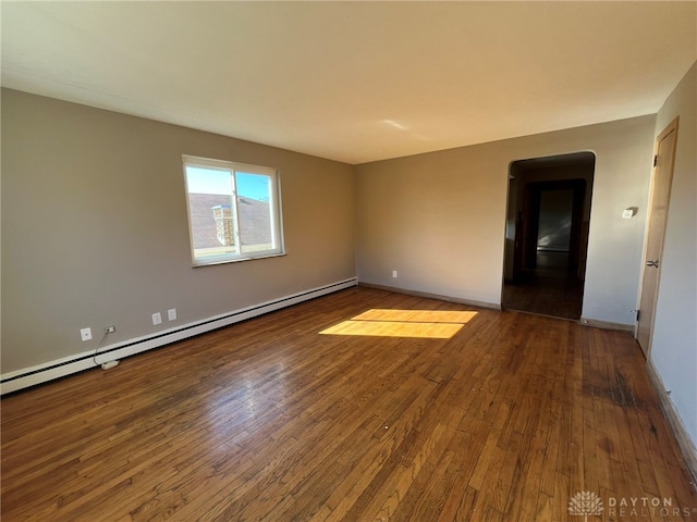 spare room featuring a baseboard radiator and hardwood / wood-style flooring