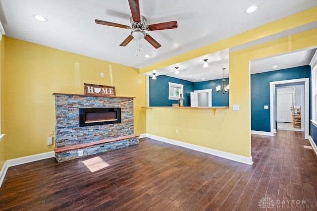 living room featuring a fireplace, ceiling fan with notable chandelier, and hardwood / wood-style flooring