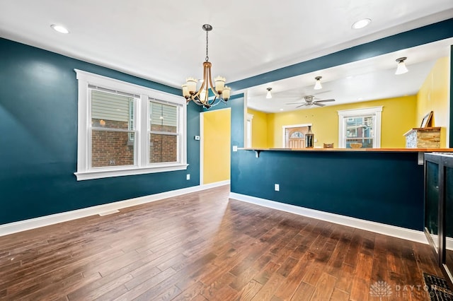 interior space featuring ceiling fan with notable chandelier and dark hardwood / wood-style flooring