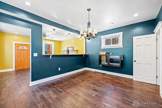 interior space with dark hardwood / wood-style floors and ceiling fan with notable chandelier