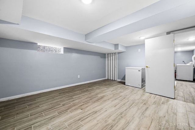 basement with fridge, light wood-type flooring, and washer / clothes dryer