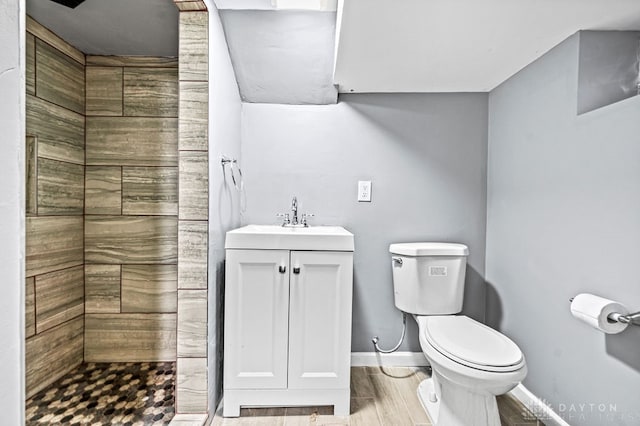 bathroom with toilet, a shower, vanity, and hardwood / wood-style floors