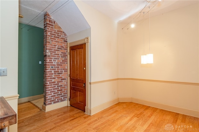 empty room with hardwood / wood-style floors and lofted ceiling