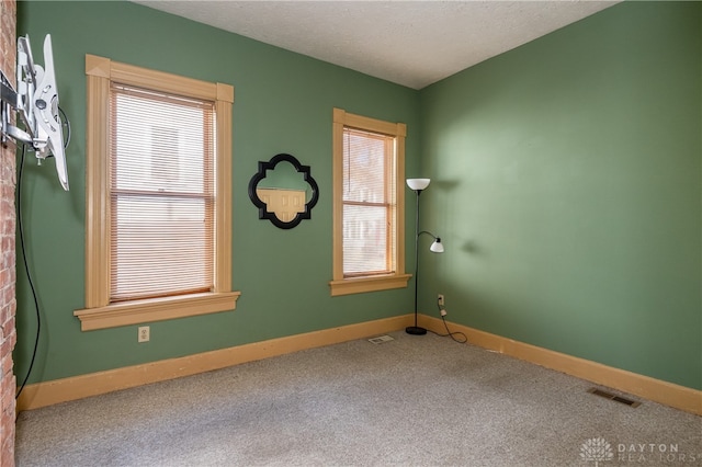 carpeted empty room with a textured ceiling